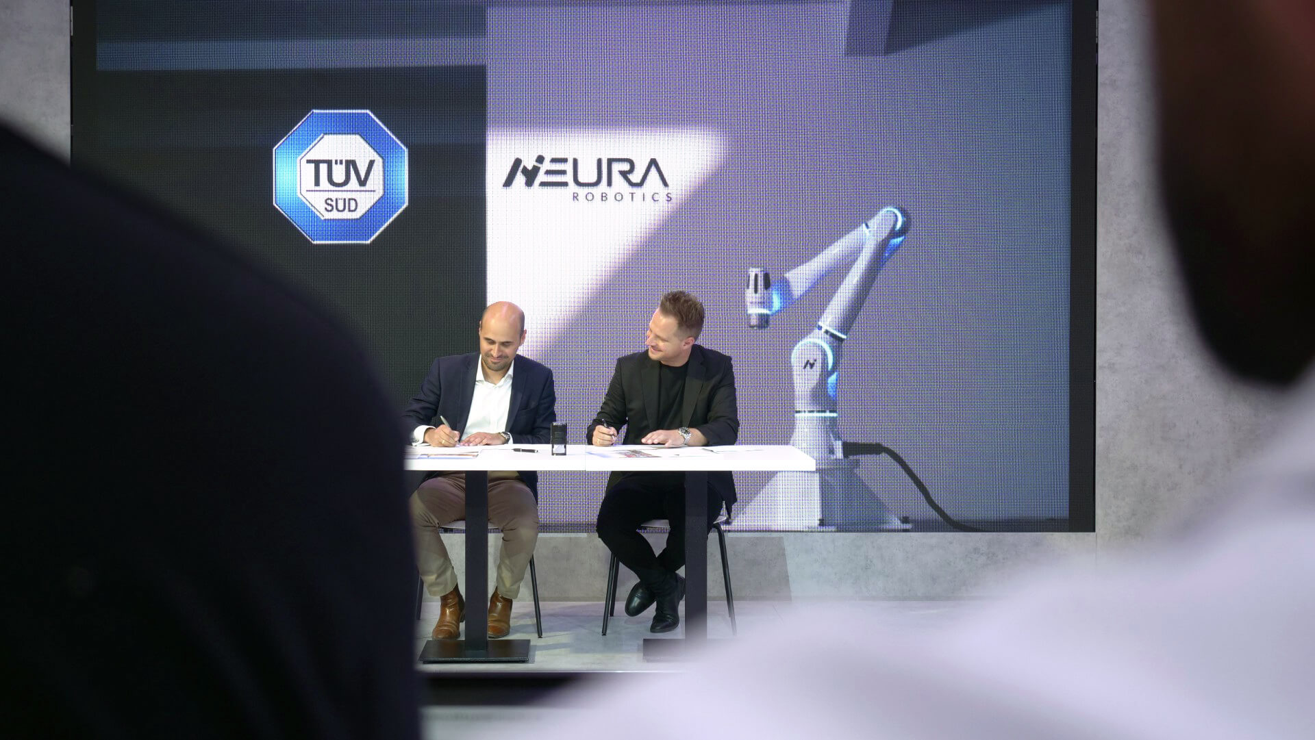 Marcello Walz, Head of Advanced Manufacturing at TÜV SÜD and David Reger, founder and CEO of NEURA Robotics signing the partnership