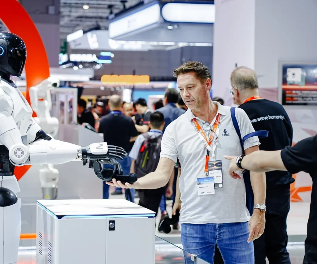 4NE1 handing a giveaway to a visitor · alt text: "4NE1 humanoid robot handing a giveaway to a visitor at CIIF 2026